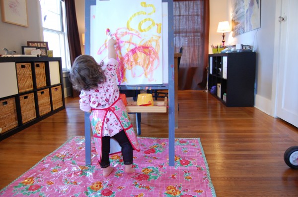 one year old painting at the easel